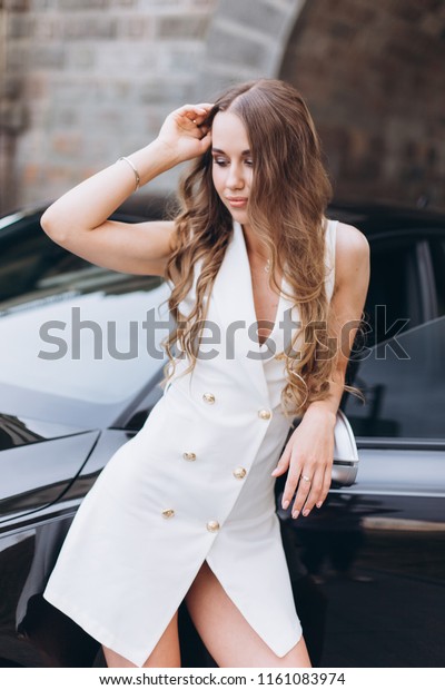 Young\
gorgeous russian luxury model with beautiful long hair, slim and\
sexy style posing outdoors near new sport car\
