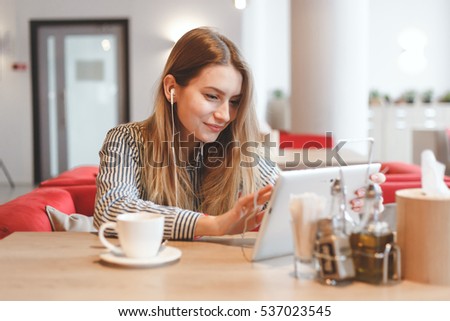Young gorgeous woman wathing video online at the cafe