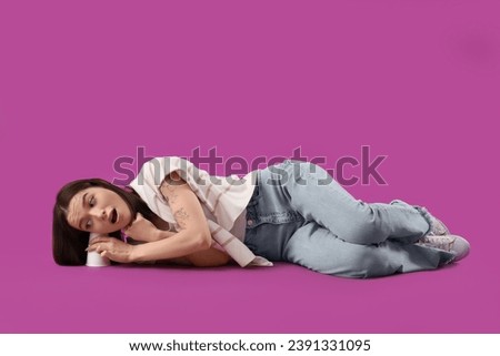 Young gossip woman with cup trying to hear something on purple background