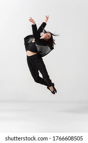 Young and graceful ballet dancer in minimal black style isolated on white studio background. Art, motion, action, flexibility, inspiration concept. Flexible caucasian ballet dancer, weightless jumps. - Shutterstock ID 1766608505