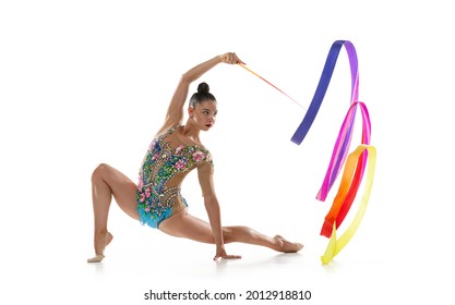 Young graceful girl, female rhythmic gymnast training with bright colored ribbon isolated over white studio background. Concept of action, motion, sport life, competition. - Powered by Shutterstock