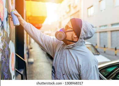 Young Graffiti Artist Painting Mural Outdoors On Street Wall.