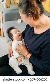 Young Grandma Holding A Newborn Baby