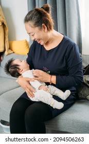 Young Grandma Holding A Newborn Baby