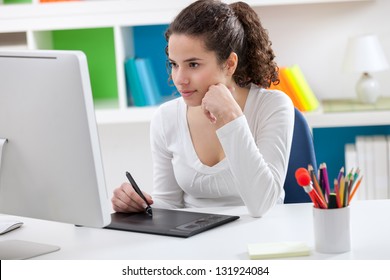 Young Graphic Designer Working On Computer Using Tablet At Home