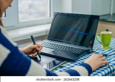 Young graphic designer working on laptop using tablet at home. - Shutterstock ID 262663208