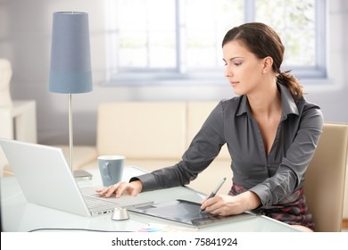 Young Graphic Designer Working On Laptop Using Tablet At Home.?