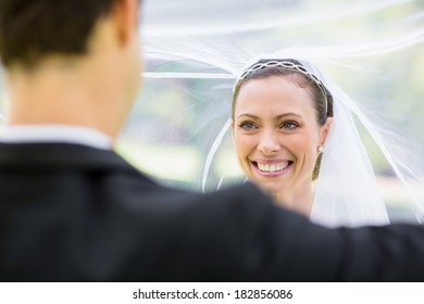 Young groom lifting bridal veil in garden - Powered by Shutterstock