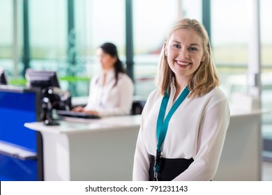 Young Ground Staff Smiling While Colleague Working At Airport Re