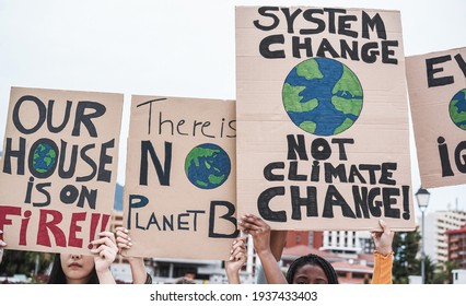 Young group of demonstrators on road from different culture and race protest for climate change - Focus on banners - Shutterstock ID 1937433403