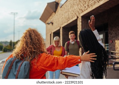 A Young Group Of Diverse Friends Are Reunited At University. They Are Eager To Greet And Hug Each Other.