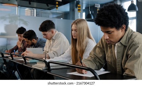 Young Group Of Diverse Serious People Writing College Entrance Exam Thinking About Question Difficult Test Students Write Notes Essay Sit In Classroom At Desk Higher Education Concept At University