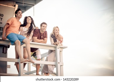 Young Group of Friends at the Beach on the Lifeguard stand in Southern California - Powered by Shutterstock