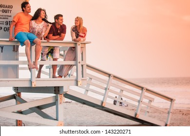 Young Group of Friends at the Beach at Sunset with American Flags - Powered by Shutterstock