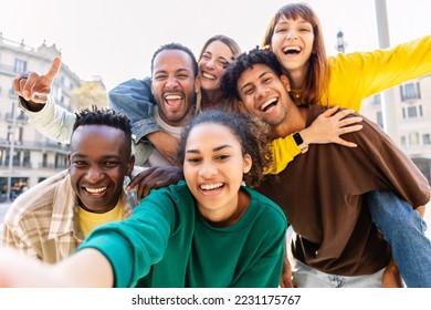 Young group of happy multiracial friends taking selfie portrait in the city. United millennial people laughing and enjoying time together outdoor. Happiness and friendship concept - Powered by Shutterstock