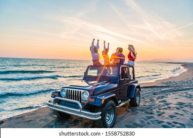 Young group having fun on the beach drink beer and dancing in a convertible car - Powered by Shutterstock