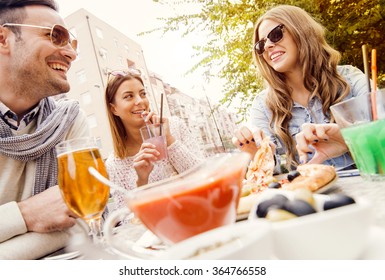 Young Group Of Laughing People Eating Pizza And Having Fun