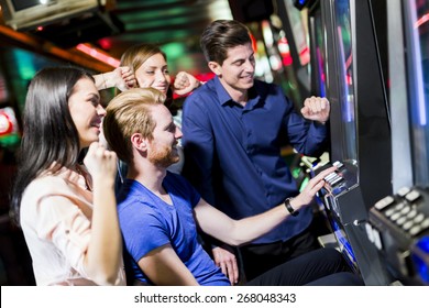 Young Group Of People Gambling In A Casino Playing Slot And Various Machines