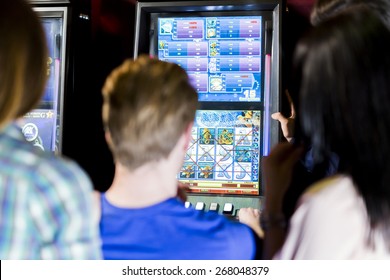 Young Group Of People Gambling In A Casino Playing Slot And Various Machines