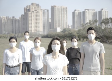 Young Group Wearing Mouth Mask Against Air Pollution In City