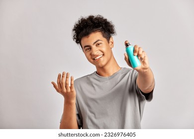 Young guy with black curly hair applies face wash to his hands, ready to take on his daily grooming and skincare routine. Man preparing for a good face wash, the foundation of fresh and healthy skin. - Powered by Shutterstock