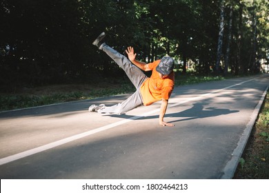 Young guy breakdancer dancing breakdance on the road in the park in summertime. Breakdancing school poster