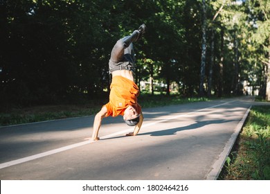 Young guy breakdancer dancing on the road in the park in summertime. Breakdancing school poster
