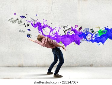 Young guy in casual evading from colorful splashes