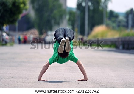 Young guy dancing breakdance on the street