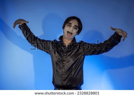 The young guy with dark makeup celebrating a Halloween party or Day of the Dead. A gothic-punk man with a face painted in the make-up of cosplay  wizard, vampire, devil Stock photo © 