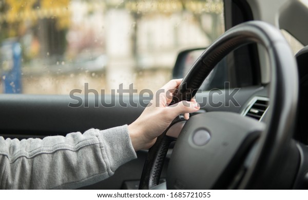 Young\
guy driving a car in a cloudy day without car\
logo