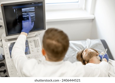 Young guy during an ultrasound diagnosis of the carotid artery. Concept of ultrasound diagnostics and men's health. Idea of examination of cardiovascular diseases