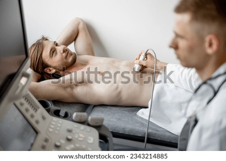 Young guy during an ultrasound diagnosis of the lower abdomen. The concept of ultrasound diagnostics and men's health