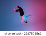 young guy falls upside down in the air, man levitates and flies down in neon lighting, acrobat dancer flies in a jump, concept of dreams and fantasies