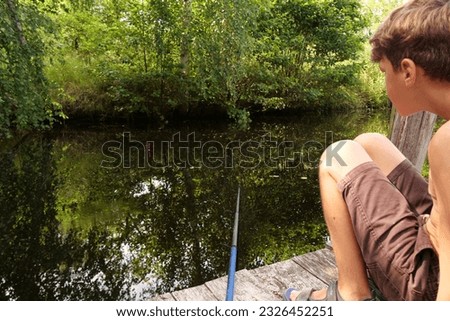a young guy is fishing on the lake