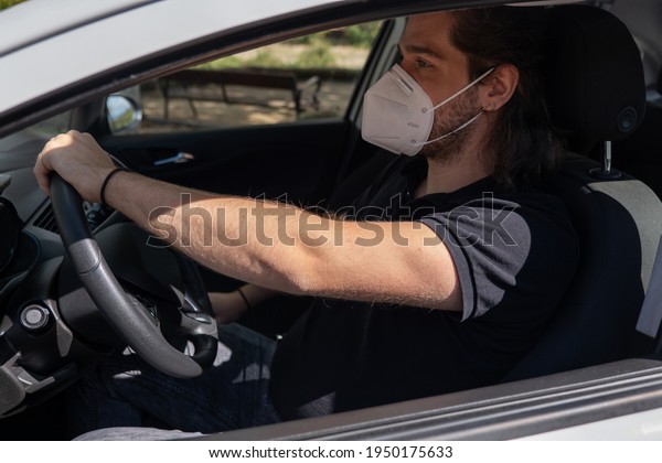 Young guy with long hair wearing a face mask by\
COVID-19 driving