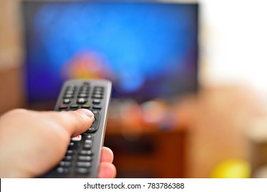 Young guy looking at camera while switching TV channels