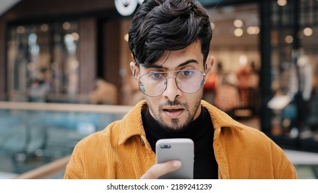 Young Guy Looking At Smartphone Screen Reading Email With Great News Surprised Rejoicing Celebrating Success Winning Online Game Gambling Got Scholarship Invitation To Work Special Offer Feeling