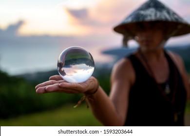 Young Guy Magician Holding A Glass Ball For Contact Juggling At Sunset