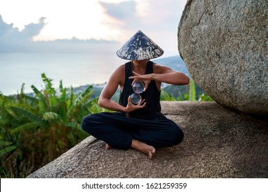 Young Guy Magician Holding A Glass Ball For Contact Juggling At Sunset