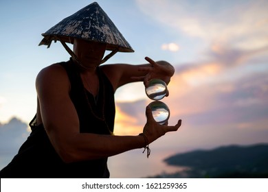 Young Guy Magician Holding A Glass Ball For Contact Juggling At Sunset