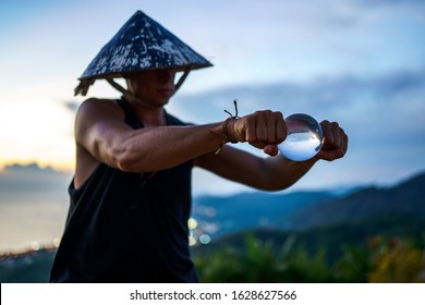 Young Guy Magician Holding A Glass Ball For Contact Juggling At Sunset