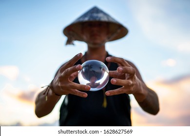 Young Guy Magician Holding A Glass Ball For Contact Juggling At Sunset