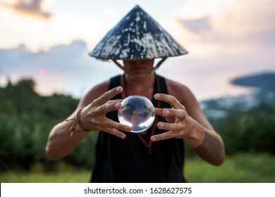 Young Guy Magician Holding A Glass Ball For Contact Juggling At Sunset