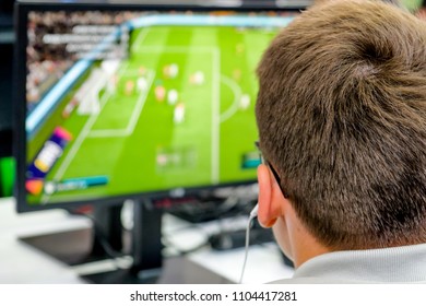 Young guy playing computer soccer. Guy watches screen. 