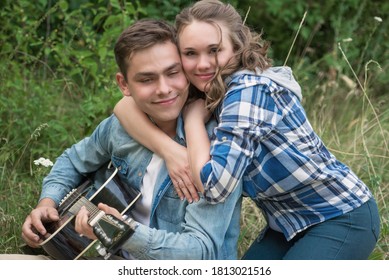 Young Guy Playing Guitar For Girl At Picnic