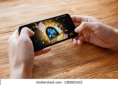 a young guy plays Blizzard game on the phone. Smartphone closeup without a face. - Shutterstock ID 1383831422