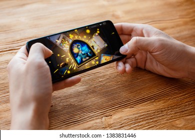 a young guy plays Blizzard game on the phone. Smartphone closeup without a face. - Shutterstock ID 1383831446