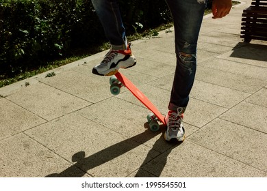 Young Guy In Ripped Jeans Standing With Penny Board In The Park. Summer Activities Skateboarding