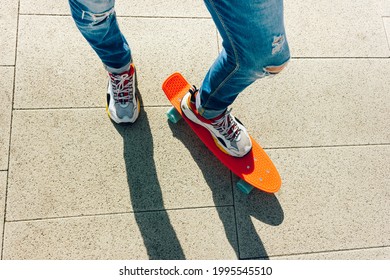 Young Guy In Ripped Jeans Standing With Penny Board In The Park. Summer Activities Skateboarding